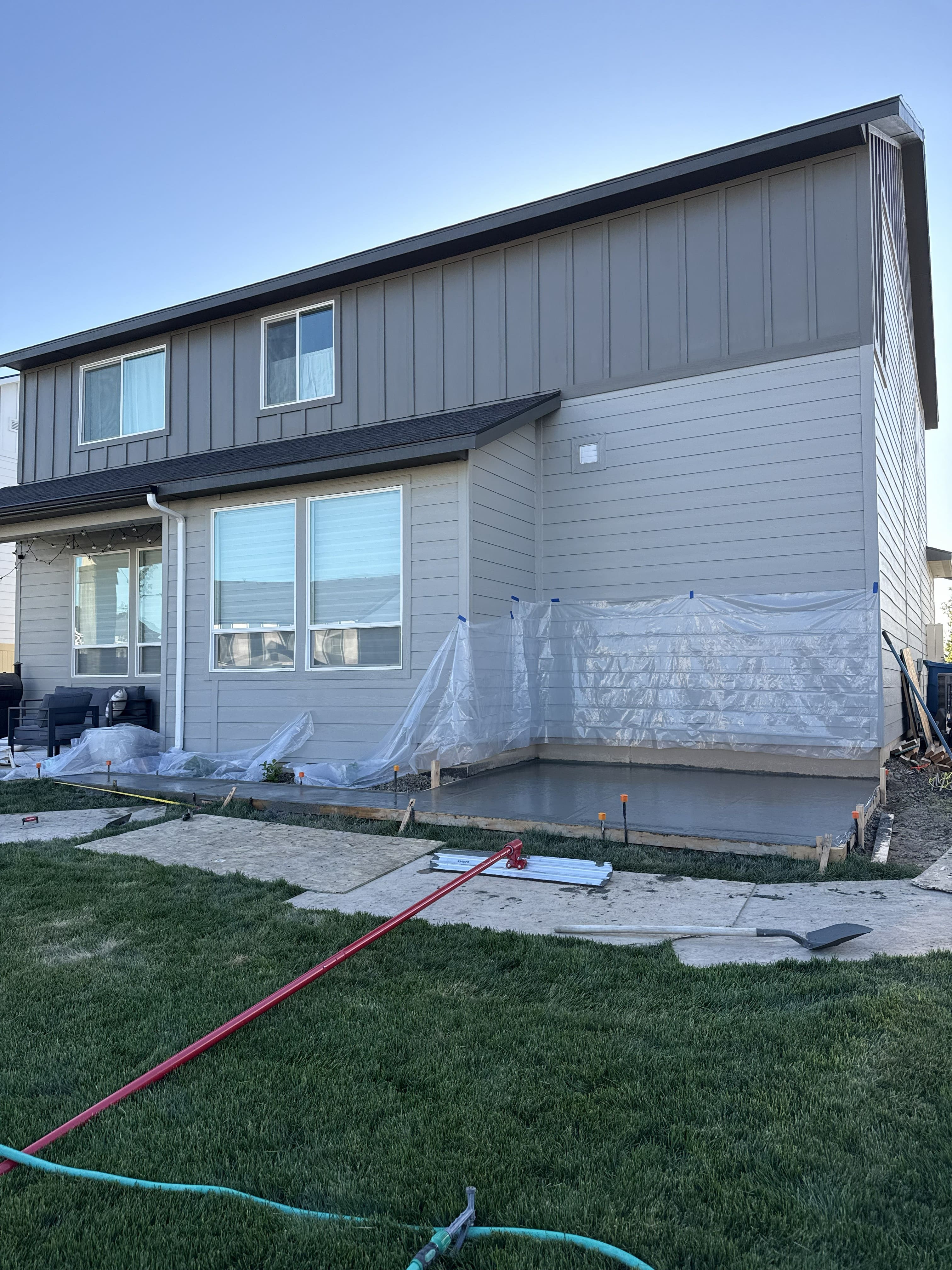Fresh concrete patio being installed beside a Treasure Valley home