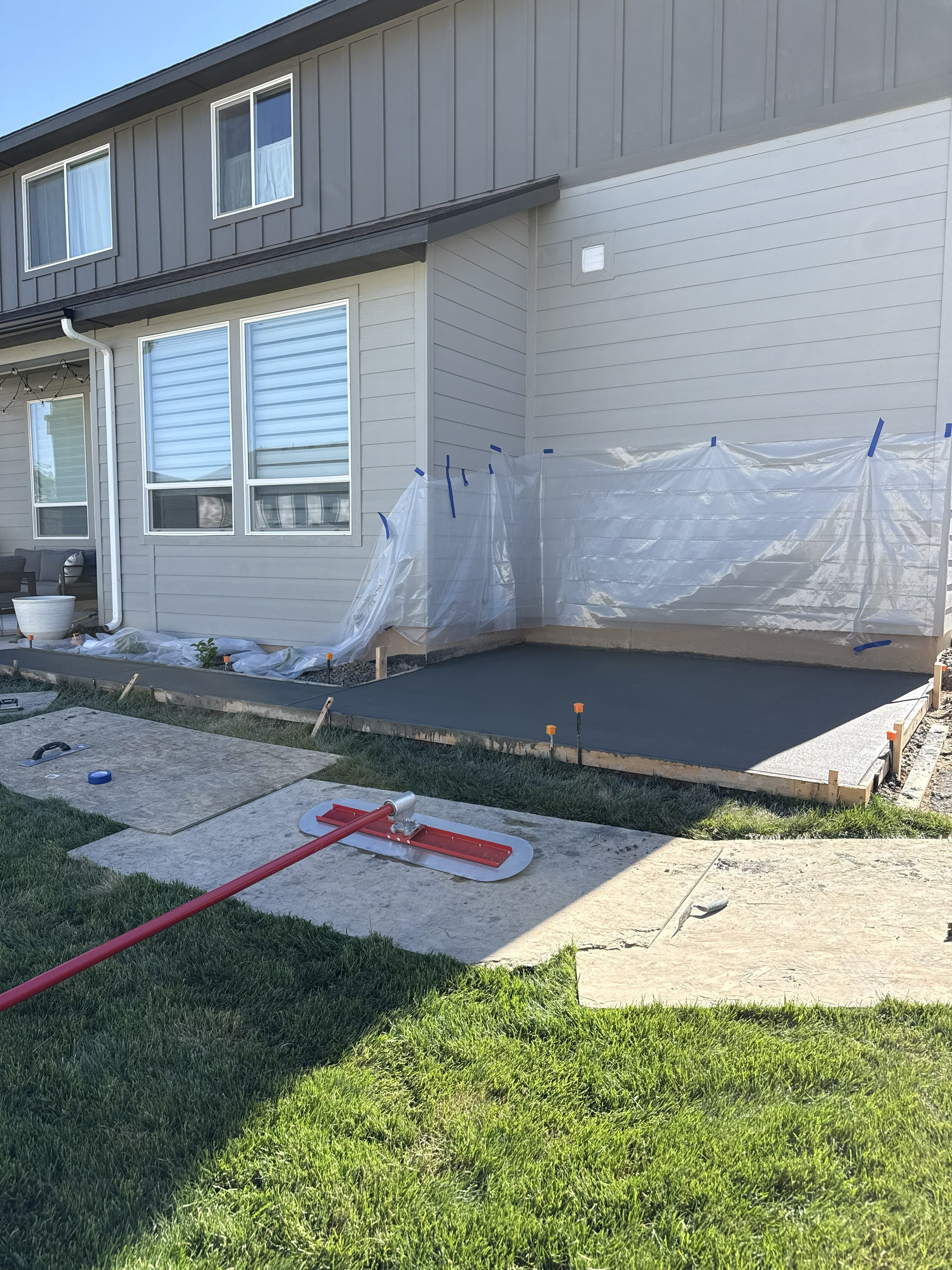 Concrete patio during finishing beside a residential walkway