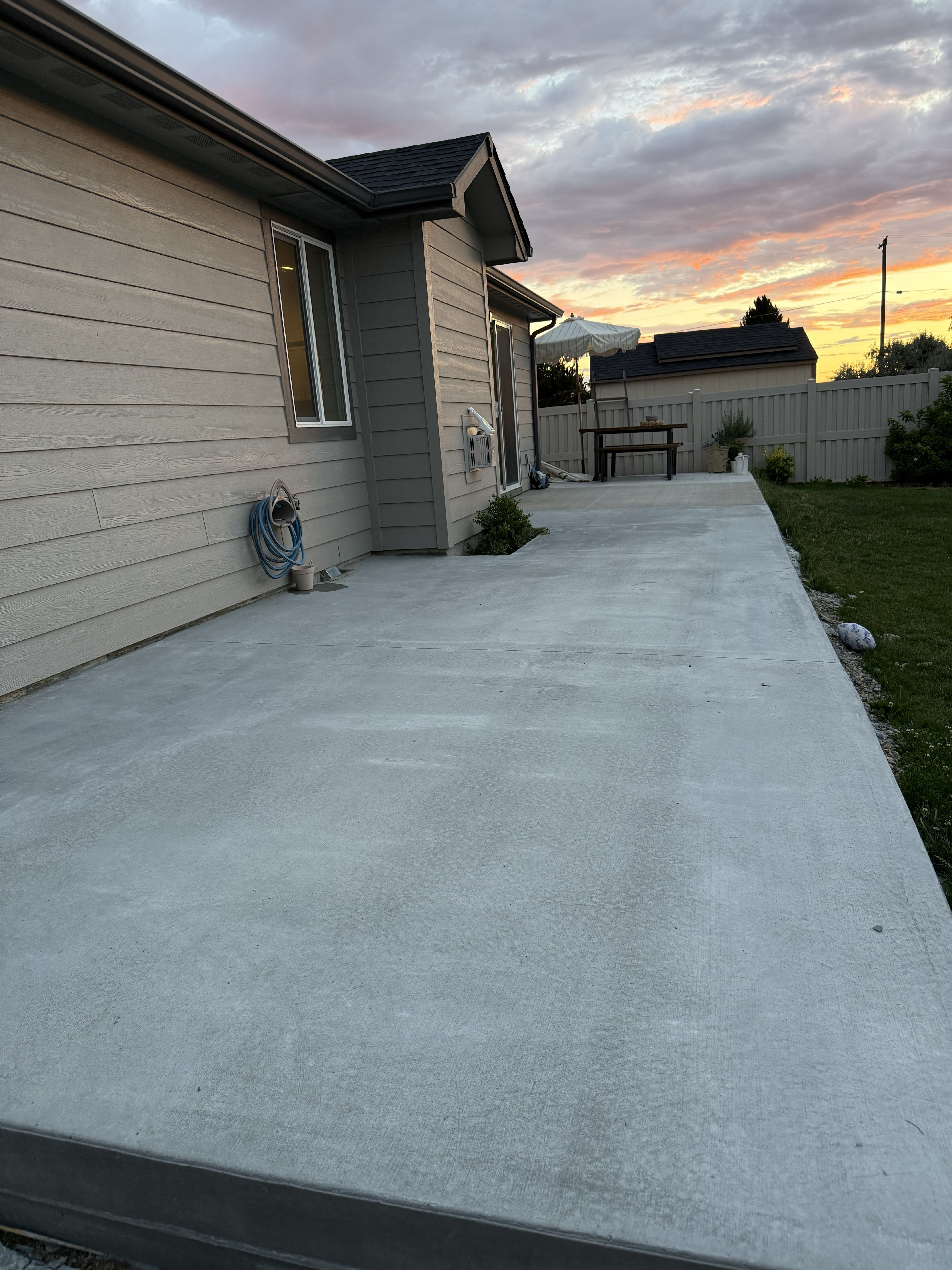 Long finished residential concrete slab beside a home at sunset